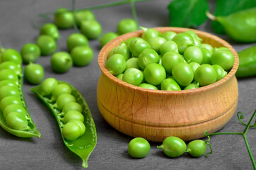 Fresh green peas in wooden bowl