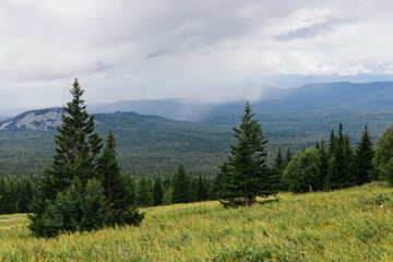 View on a rain clouds over mountain forest valley in Russia
