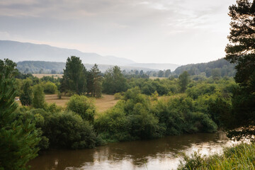 Beautiful sunset fog over river after rain in russian mountains