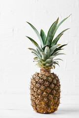 Ripe pineapple on a white wooden table.