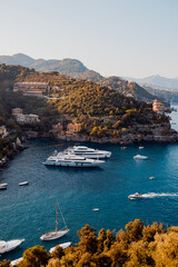 Liguria, Italy, Europe. Luxury yachts and boats in The beautiful Portofino with colorful houses and villas, in little bay harbor.