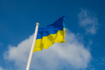 Flag of Ukraine on the blue sky. Close-up of waving Ukraine flag. Symbols of the flag of Ukraine. Ukraine flag frame with blank space for your text. 