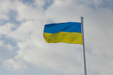 Flag of Ukraine on the blue sky. Close-up of waving Ukraine flag. Symbols of the flag of Ukraine. Ukraine flag frame with blank space for your text. 