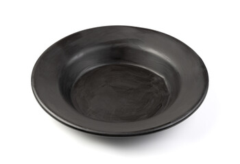 An old black soup plate on a white background.