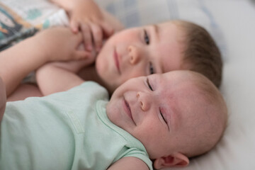 Niños bebés hermanos jugando en la cama de sus padres abrazados