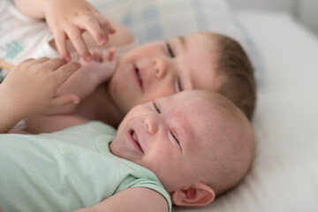 Obraz na płótnie Canvas Niños bebés hermanos jugando en la cama de sus padres abrazados
