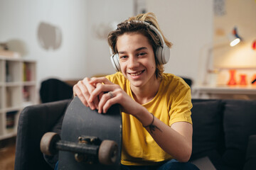teenager boy listening music on headphones at home