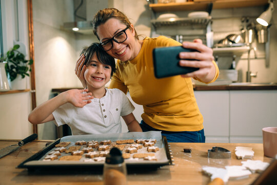 mother and her son having fun while preparing food in kitchen