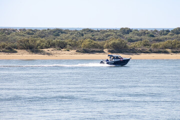 Obraz premium Motor speed boat navigating the bay of El Portil beach in Punta Umbría, Huelva. Video in Slow motion