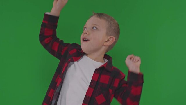 Happy cute child dancing over green background