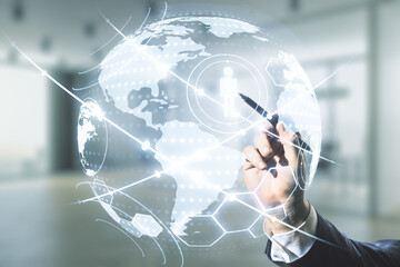 Man hand with pen working with virtual social network hologram and world map on blurred office background. Multiexposure