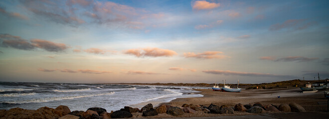 Beach of norre vorupor, denmark, sunset over old fishing boats