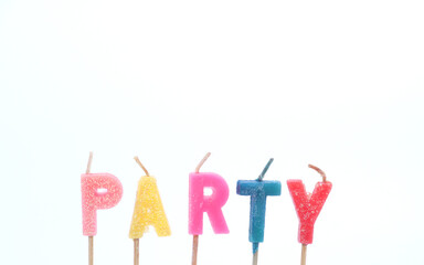 A candle with the word " PARTY " in bright colors against a white background.