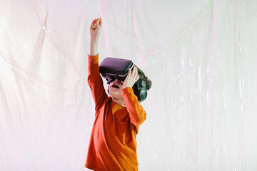 Happy kid interacting with virtual reality in studio