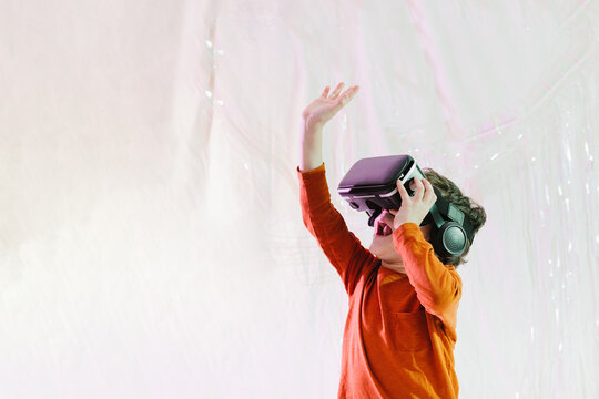 Happy kid interacting with virtual reality in studio