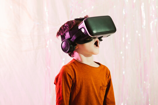 Amazed boy in VR glasses in studio
