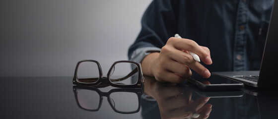 Businessman is working on mobile and laptop. stock business on smartphone. Man programmer using laptop computer with internet network connection.