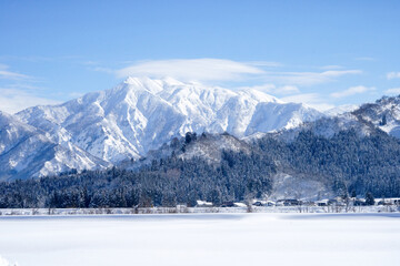 雪で覆われた真白な巻機山と手前に広がる白い野原