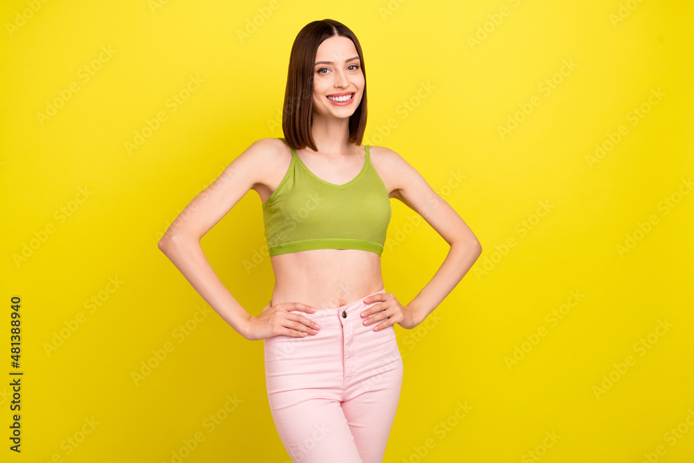 Wall mural Photo of pretty brunette millennial lady wear green top jeans isolated on yellow color background - Wall murals