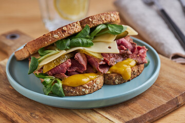 Delicious sandwich with egg and meat in toasted bread on plate