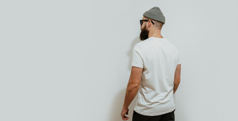 Young bearded hipster guy wearing white blank t-shirt. Mock-up for print. T-shirt template.