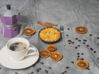 Coffee pot with coffee beans, dried oranges, apple pie, on a brown background.