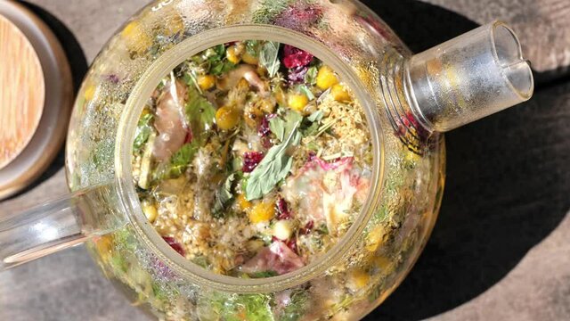 herbal teas in transparent glass pot, dries herbs, flowers. Healthy antioxidant hot drink