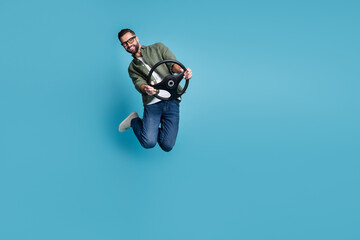 Naklejka na ściany i meble Full size photo of jumping man hold steering wheel traveling having fun isolated on blue color background