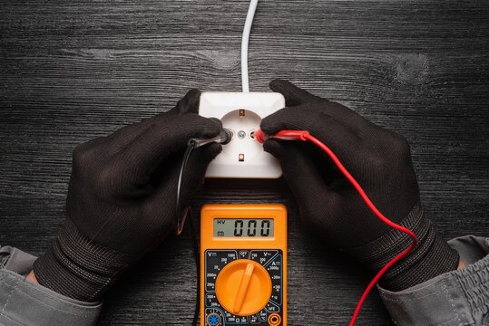 No mains voltage in the electric plug  concept. Electric voltmeter with zero on the display and hands of electrician.