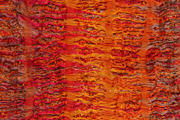 The bright fabric is orange with red, textured, light.