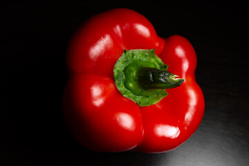 Fresh red sweet pepper close-up on a dark background.