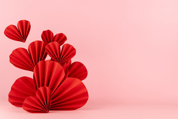 Valentines day scene in asian style - fly red paper hearts of folded fans on pastel pink color,...