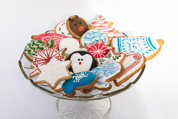 Traditionally decorated handamde Christmas gingerbread cookies served on a glass bowl