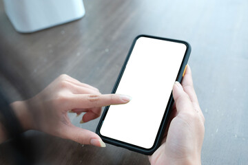 Close up of women's hands holding cell telephone with blank copy space scree for your advertising text message or promotional content, hipster girl watching video on mobile phone during coffee break