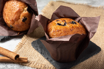 Two blueberry muffins on a light background. Blueberry muffins