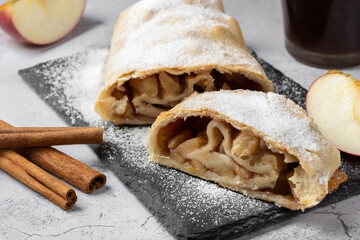 Strudel with apples sprinkled with powdered sugar on top. Traditional apple strudel with sprinkles