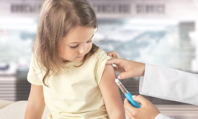 COVID 19 Vaccination for Kids concept. Hands of a nurse giving a first dose of Covid Vaccine in...