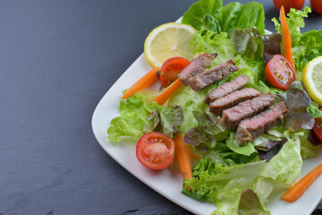 Healthy vegetable and beef salad of fresh tomatoes,lettuce,carrot on plate. Diet menu.