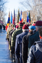 Selective focus back view of senior veterans marching on Grande-Allée street during the Remembrance Day Ceremony, Quebec City, Quebec, Canada