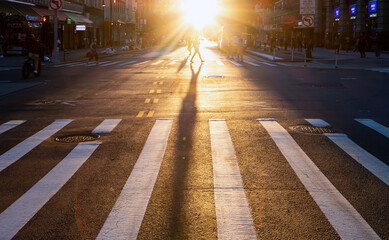 New York City - Person walking across the crosswalk on 14th Street and 5th Avenue in Manhattan with...