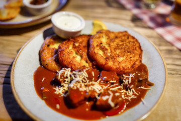 Potato pancakes with stew on a plate in a restaurant.