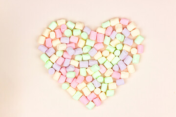 Pastel multicolor heart shape marshmallow put on pastel pink background. Food background. Holiday and celebration concept