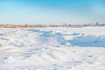Fototapeta na wymiar Chunks of ice on a frozen river on a sunny winter day