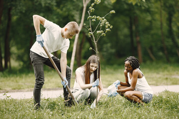 Young volunteers planting a tree together at park