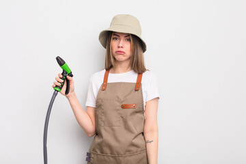 pretty young woman feeling sad and whiney with an unhappy look and crying. gardener watering concept