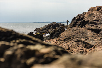 Fisherman on rocky shore, Rhode Island
