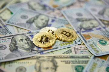 Three symbolic coins are crooked on banknotes one hundred dollars. Exchange bitkoyn cash for the dollar.