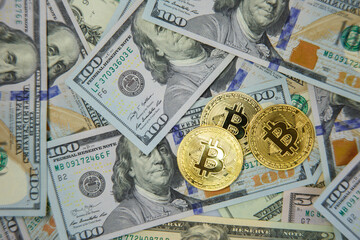 Golden bitcoins lie on many dollar bills. The concept of lowering the price of bitcoins relative to the US dollar