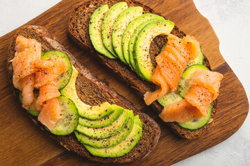 Avocado toast with smoked salmon on cutting board close up