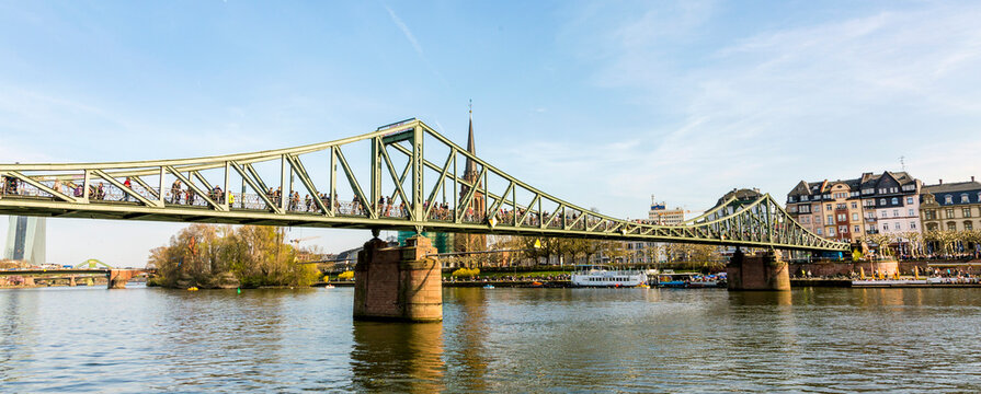 people at bridge eiserner steg in Frankfurt with river Main